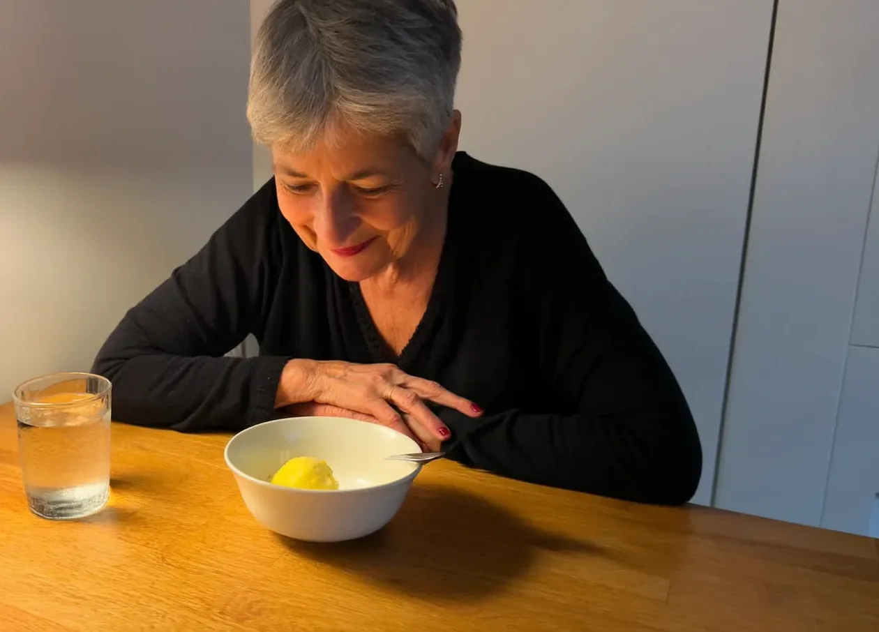 Woman looking at a small bowl of lemon sorbet