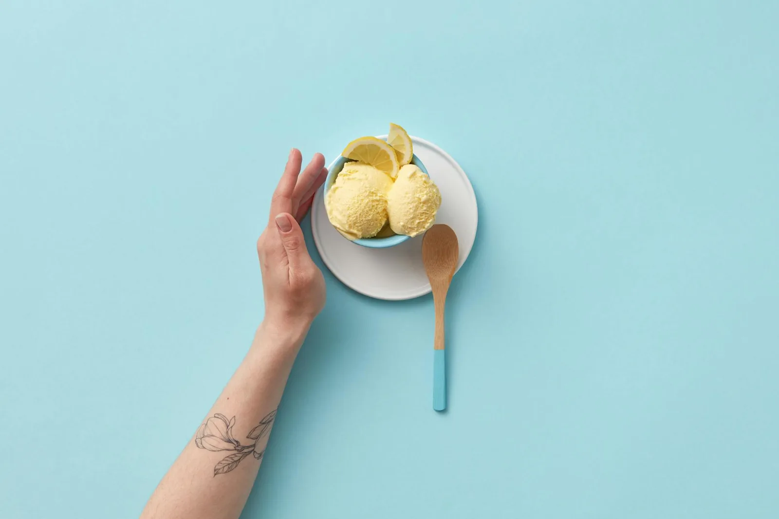 Bright lemon sorbet served in a ceramic bowl with a wooden spoon, highlighting its vivid fruit-forward character.