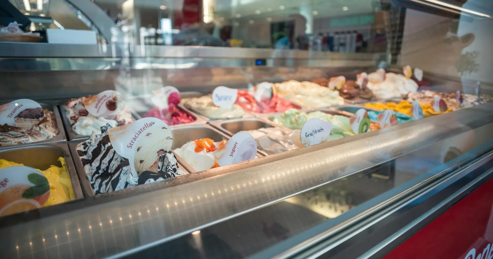 Colorful assortment of gelato flavors arranged in a gelateria display case.